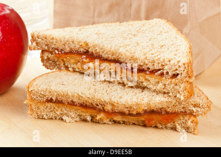 Erdnussbutter und Gelee Lunchpaket mit Wasser und Apfel Stockfoto