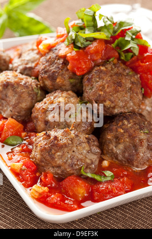 Hausgemachte Frikadellen in rote Tomatensauce auf einem Hintergrund Stockfoto