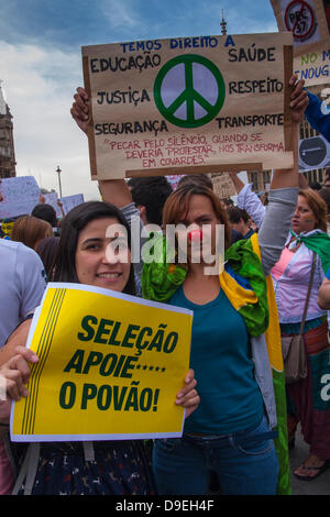 London, UK. 18. Juni 2013. Demonstranten werfen ihre Plakate wie brasilianische Auswanderer in London Aginst Regierungskorruption, spiralförmigen WM und Olympischen Spielen Kosten und steigende Transportkosten, in Solidarität mit ihren Landsleuten zu Hause unter Beweis stellen. Stockfoto