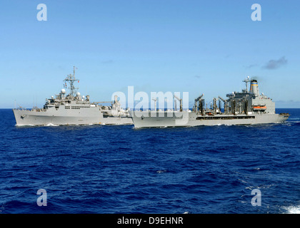 USS Denver und USNS Pecos führen ein Nachschub auf dem Meer. Stockfoto