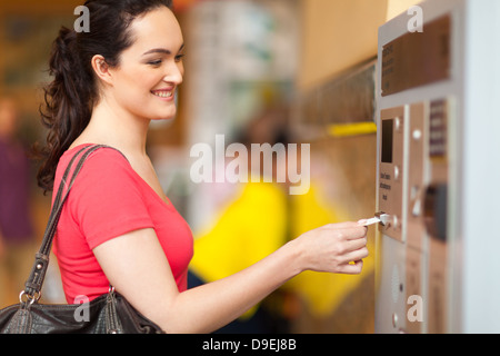 junge Frau, die für das Parken an der Mautstation bezahlen Stockfoto