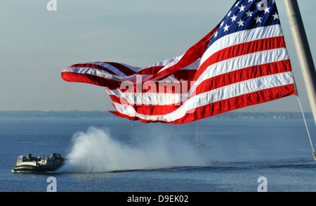 Amerikanische Flagge im Wind wehen, mit einem Hovercraft im Hintergrund. Stockfoto