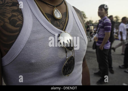 23. März 2013 - Nakhon Chai Si - A Anhänger trägt Spiegel Sonnenbrille während der Teilnahme an einem Tattoo Festival in der Nähe von Nakhon Chai Si auf Dienstag, 26. März 2013.  Anhänger haben ihre Tätowierung Tattoo Meister und buddhistische Mönche erregt.  Die meisten Anhänger glauben, dass die Tätowierungen magisch sind und Schutz gegen solche Dinge wie Kugeln und Messer. (Kredit-Bild: © David Longstreath/ZUMAPRESS.com) Stockfoto