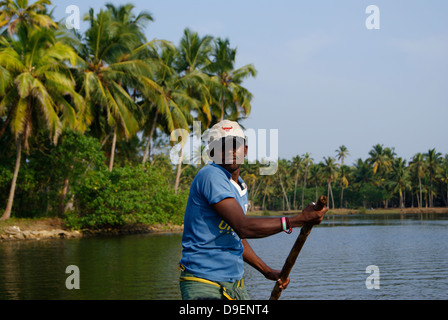 Boot-Mann Rudern Land Holzboot in Kerala Backwaters, Indien Stockfoto