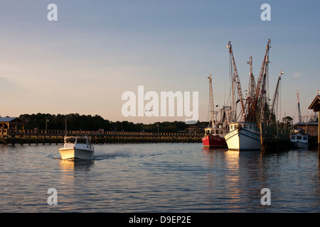 Die Sonne geht auf der aktiven Uferpromenade entlang Shem Creek, Mount Pleasant, South Carolina, USA in ein warmes Licht baden. Stockfoto