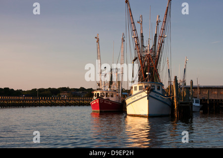 Die Sonne geht auf der aktiven Uferpromenade entlang Shem Creek, Mount Pleasant, South Carolina, USA in ein warmes Licht baden. Stockfoto