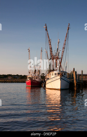 Die Sonne geht auf der aktiven Uferpromenade entlang Shem Creek, Mount Pleasant, South Carolina, USA in ein warmes Licht baden. Stockfoto