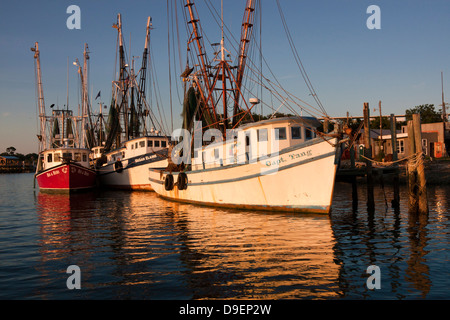 Die Sonne geht auf der aktiven Uferpromenade entlang Shem Creek, Mount Pleasant, South Carolina, USA in ein warmes Licht baden. Stockfoto