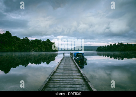 Alte Mole und Fischerboot vor Anker am Ende, Lake Mapourika, auf der Westküste von Neuseelands Südinsel. Stockfoto