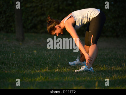 (Model Release) Junge Frau beim Aufwärmen, dehnen, stretching, Yoga, Joggen Stockfoto