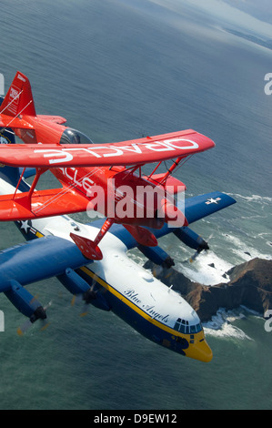 Eine c-130 Hercules Fat Albert Flugzeuge und Doppeldecker fliegen über die Bucht von San Francisco. Stockfoto