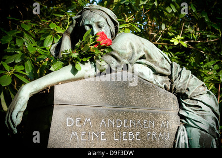 Statue einer Frau mit Rosen auf dem waschechter Friedhof in Hamburg, Statue einer Frau mit Rosen auf dem Dorffriedhof Ohls in Stockfoto