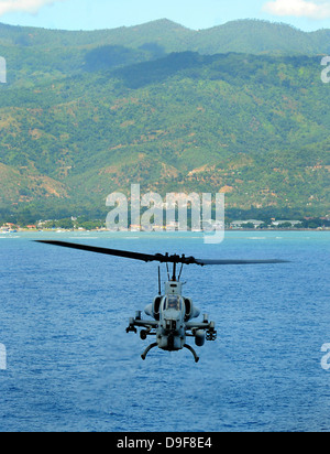 Ein AH-1W Super Cobra fliegt die Küste von Dili, Osttimor. Stockfoto