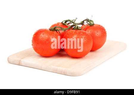 Strauch-Tomaten auf einem Holzbrett Tomaten auf einem Holzbrett Stockfoto