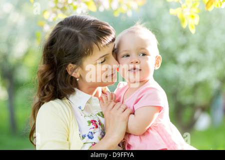 süße Mutter mit Babymädchen im freien Stockfoto