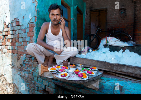 Mann spricht auf einem Mobiltelefon außerhalb sein Geschäft in einem Dorf in der Nähe von Delhi, Indien. Indische Wirtschaft. Stockfoto