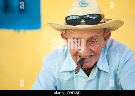 Porträt des alten Mann mit Strohhut posiert vor einer gelben Wand für touristische Pesos, Trinidad, Kuba, West Indies Stockfoto