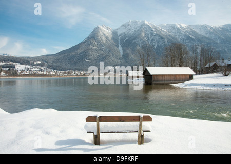 Eine schneebedeckte Bank mit Blick auf Hallstätter See und die umliegenden Berge nahe der Stadt von Hallstatt, Österreich Stockfoto