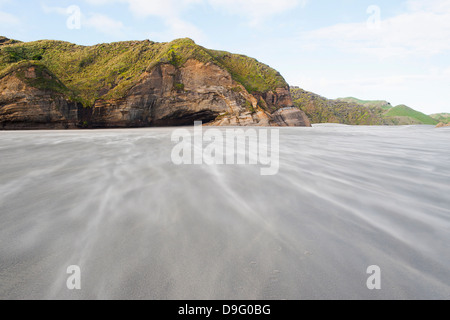Sand in die Luft gesprengt an windigen Wharariki Beach, Golden Bay, Tasman Region, Südinsel, Neuseeland Stockfoto