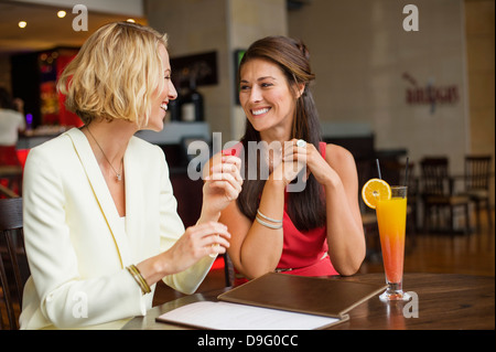 Zwei Freundinnen, die lächelnd an einander in einem restaurant Stockfoto