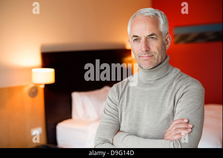 Mann mit verschränkten in einem Hotelzimmer Stockfoto