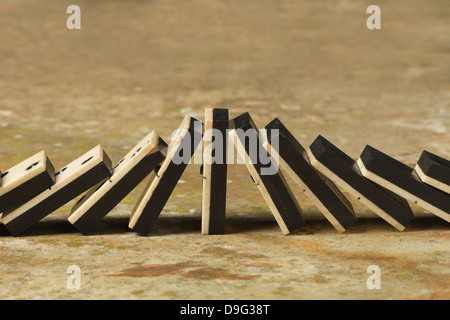 Reihen von aufgereiht altes Elfenbein und Ebenholz Bronze angehefteten stehende Domino blockiert Stücke auf weißem Tan Travertin-Marmor Stockfoto