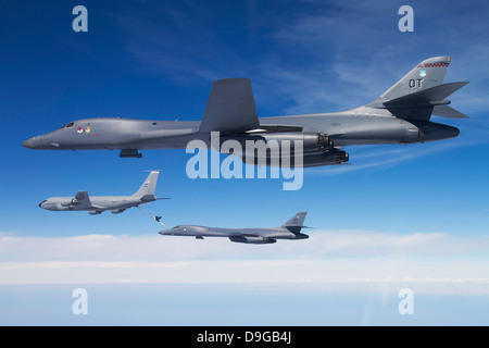 Ein B-1 b Lancer steht da ein weiteres Lancer mit einem KC-135 Stratotanker verbindet. Stockfoto