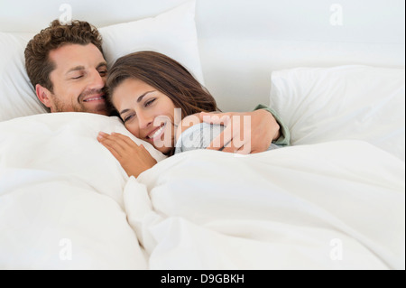 Lächelnde paar auf dem Bett liegend Stockfoto