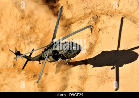 Ein UH-60 Black Hawk-Hubschrauber ist für eine Landung Staub. Stockfoto