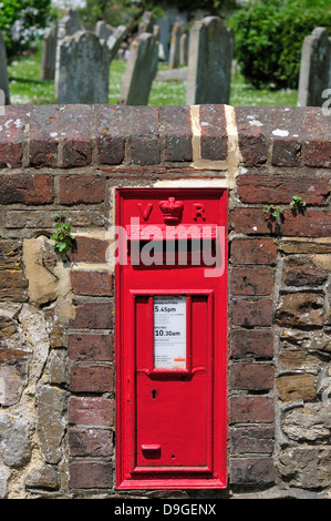 Roggen, East Sussex, England, UK. Viktorianischer Briefkasten in Wand von dem Kirchhof Stockfoto