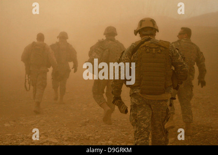 US-Soldaten und Marines gehen durch Staub von der Rotor-Wäsche aus einem UH-60 Black Hawk Hubschrauber während des Betriebs 5. Januar 2011 in Darrah-ich-Bum, Provinz Badghis, Afghanistan 5. Januar 2011 erstellt. Stockfoto