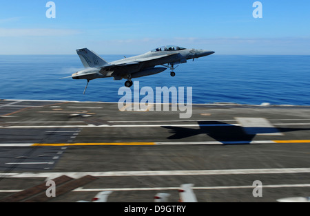 Eine F/A-18F Super Hornet fliegt über dem Flugdeck der USS George H.W. Bush. Stockfoto