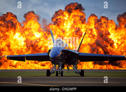 Eine Wand aus Feuer ausbricht, hinter einem Flugzeug der US Navy F/A-18 Hornet. Stockfoto