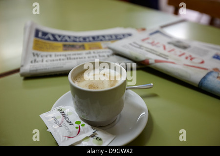 Café con Leche Milchkaffee mit spanische katalanische Zeitungen in einer kleinen bar Café in Baga Katalonien Spanien Stockfoto