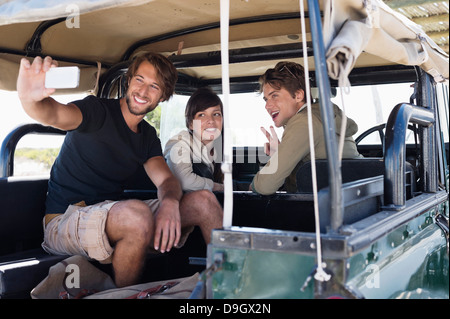 Freunde, die Aufnahme von sich selbst mit einem Mobiltelefon in einem SUV Stockfoto