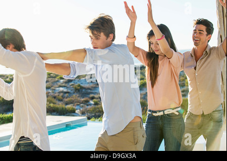 Gruppe von Freunden am Pool tanzen Stockfoto