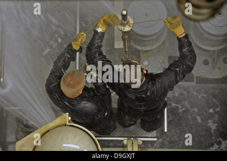 Midshipmen versuchen, ein undichtes Rohr zu patchen. Stockfoto