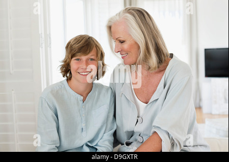 Bildnis eines Knaben mit seiner Großmutter sitzen und Lächeln Stockfoto