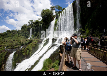 Iguazu-Wasserfälle. Einige Touristen fotografieren aus die Wege eines der Routen. Stockfoto