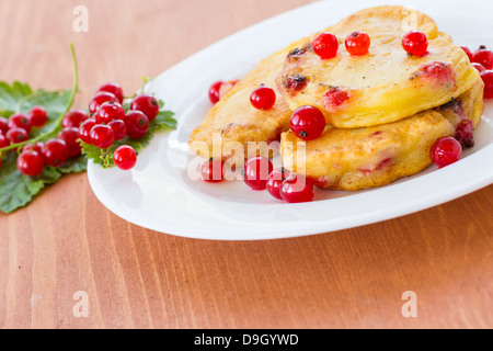 Pfannkuchen mit roten Johannisbeeren auf einem weißen Teller Stockfoto