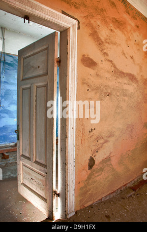 Offene Tür zu einem Raum voller Sand in Kolmanskop, eine Geisterstadt Bergbau in Namibia, Afrika. Die Wüste hat die Stadt zurückerobert. Stockfoto