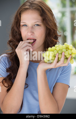 Porträt einer Frau essen Trauben Stockfoto
