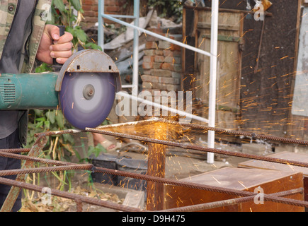 Winkel-Schleifer Metall Sägen mit blinkenden Funken hautnah und Mechaniker Hände Hauptreparatur Garten Sommer Arbeitszeit Stockfoto