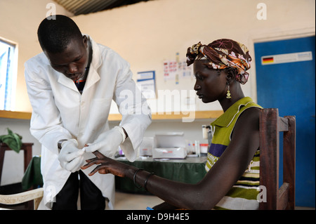 SÜDSUDAN Seen Staat, Rumbek , Gesundheitszentrum , Dinka Frau bei Blutuntersuchungen auf HIV AIDS Malaria und tropische Krankheiten in ländlichen Gesundheitsstation Stockfoto