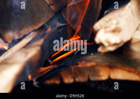 Flammen und Glut in einem Holzofen Stockfoto