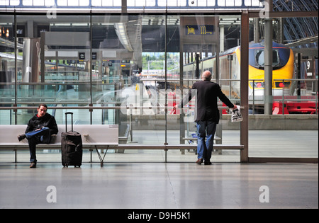 London, England, Vereinigtes Königreich. Internationaler Bahnhof St Pancras. Zwei Männer, die darauf warten vom Eurostar-terminal Stockfoto