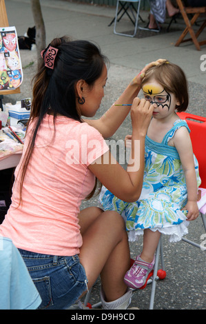 Süße junge Mädchen mit ihrem Gesicht gemalt an am jährlichen autofreien Tag-Festival auf der Main Street in Vancouver, BC, Kanada. Stockfoto