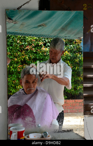 Chinesisch-Straße Seite Friseur Client Haare schneidet: Singapur Stockfoto