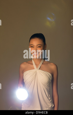 Junge Frau mit einer Taschenlampe Stockfoto