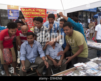 Bangladesch-amerikanische Männer beobachten die WM auf einem Laptop bei einem Straßenfest im Kensington Abschnitt von Brooklyn, NY, 2010... Stockfoto